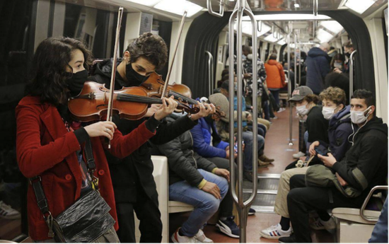 12月19日，有人佩戴口罩在巴黎地铁内为乘客演奏小提琴