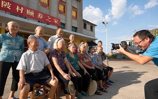 9月14日，青年志愿者为江西省新余市分宜县杨桥镇建陂村“颐养之家”的老人们拍照。