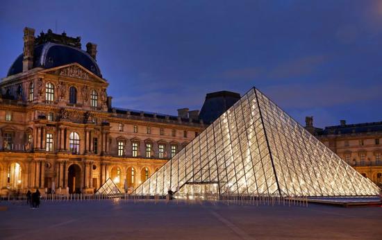 当地时间2019年3月18日，法国巴黎，卢浮宫金字塔亮起灯光，庆祝其建成30周年。它由华裔美国建筑师贝聿铭设计。视觉中国供图