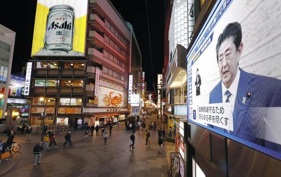 4月7日,在日本大阪,电子表现屏正在播放日本始相安倍晋三发布危险事态宣言的消息。新华社/共同社
