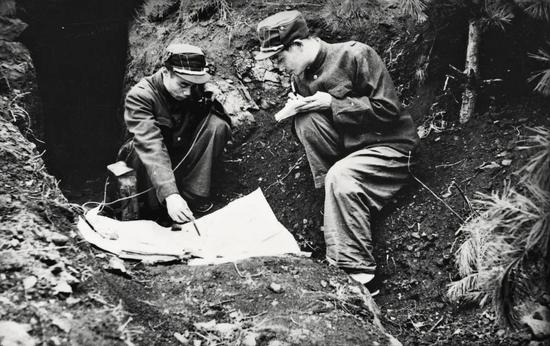 ·抗美援朝战场上，吴信泉（左）在研究作战地图。