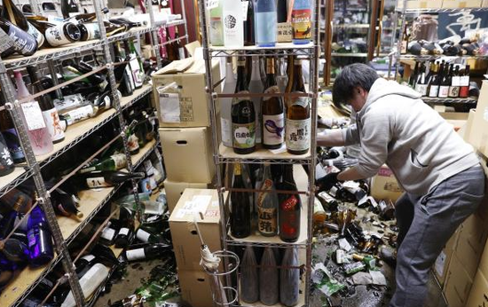 图为日本宫城县石卷市内一商店货架倒塌，瓶子碎落一地。（东方IC）