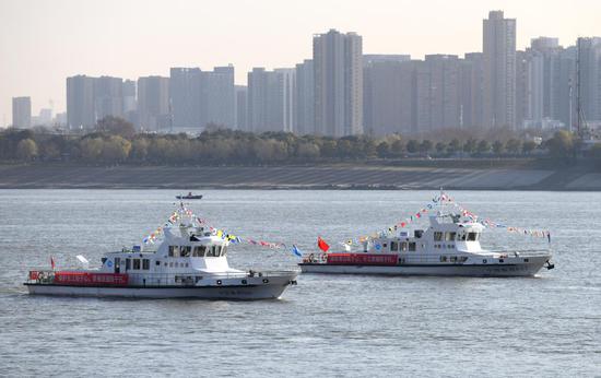 渔政执法船队从长江武汉段江面驶过（2020年12月31日摄）。新华社记者 程敏 摄