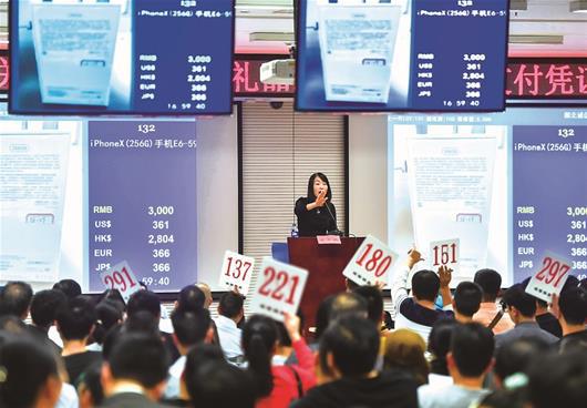 图为：昨日，武汉市公务人员上缴礼品第四次专场拍卖会在武汉市民之家举行，引来众多市民竞拍，图为拍卖现场。&nbsp;楚天都市报记者萧颢摄 　　图为：竞拍者争相举牌