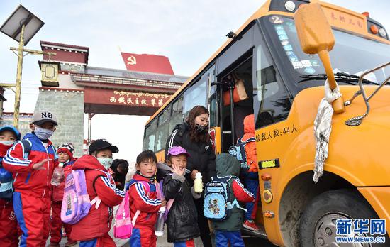 2018年3月27日，克松村的孩子们登上校车出发去幼儿园。新华社记者觉果摄