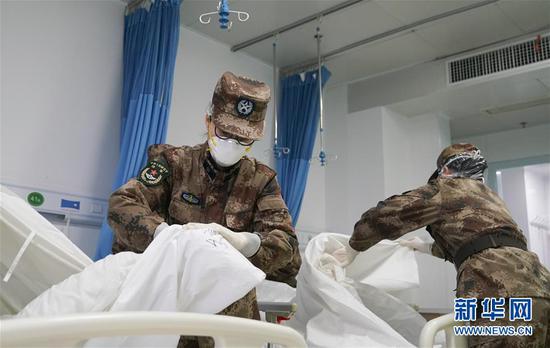 1月26日，陆军军医大学医疗队队员在武汉市金银潭医院接管病区清理病房，准备迎接患者入院。新华社记者 熊琦 摄