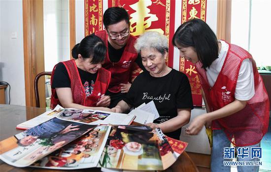 83岁的劳模教师顾月英（右二）向志愿者们讲述当年的教师生涯（9月3日摄）。 新华社记者 徐昱 摄