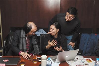 12月16日,2022年冬奥特许商品评审会现场,特许生产商与会徽设计者林存真(中)交流特许商品的改进思路。