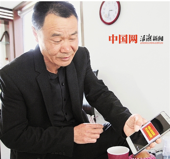 临行前，杨元中向记者展示赴朝鲜扫墓的团旗。