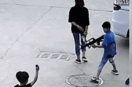 视频截图：小王因不愿被玩具枪指着，用煤渣扔向小明