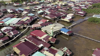 △木制房屋靠插入河底的柱子作为支撑，连片的木房子顺着河道不断延伸。（央视记者张怡、黄耀祖拍摄）