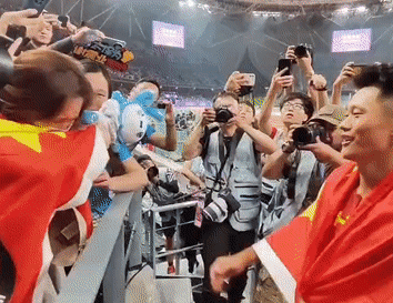  9月30日晚，杭州亚运会男子100米决赛赛后，冠军谢震业身披国旗和妻子挥泪相拥。