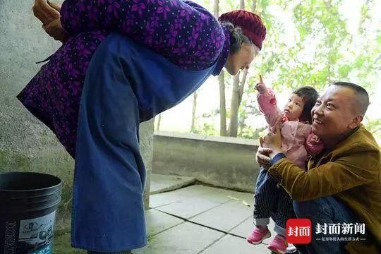 今年清明节,施先志抱着侄女的孩子,和老母亲交谈. 朱建国摄