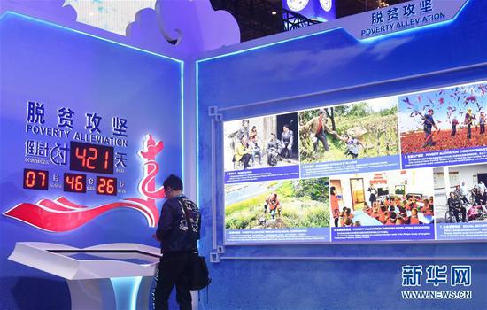 11月6日，观众在第二届进博会中国馆“美丽中国”单元脱贫攻坚倒计时显示屏前参观。 新华社记者 魏海 摄
