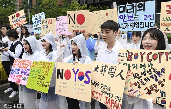 今年7月，韩国高中生冒雨在日本驻韩大使馆前举行集会，参加抵制日货活动。图源：视觉中国