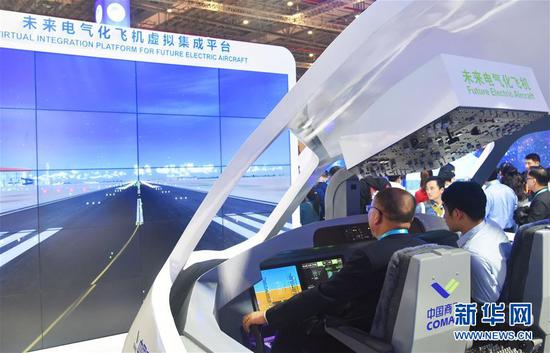 11月6日，在第二届进博会中国馆“创新中国”单元的未来电气化飞机虚拟集成平台，观众在体验中国商飞大型客机模拟驾驶舱操作。 新华社记者 魏海 摄