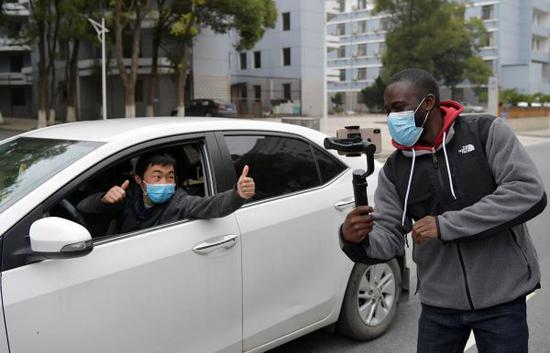 在江西财经大学校园内，尼日利亚在华留学生龙塔约（右）在和一位中国老师打招呼（2月21日摄）。新华社记者 彭昭之 摄