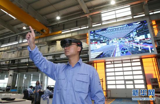 工作人员在中国商飞公司总装制造中心智慧数控车间使用AR眼镜操控虚拟电子屏幕（2018年5月5日摄）。新华社记者 丁汀摄
