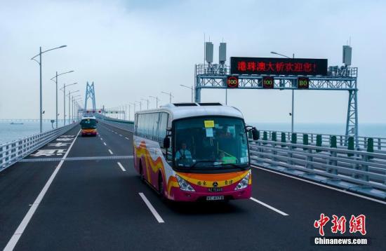 10月24日，大巴车经过港珠澳大桥青州航道桥附近。中新社记者 张炜 摄
