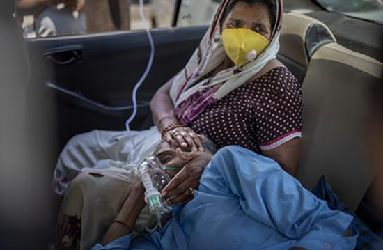 4月24日，在印度新德里，一名新冠患者在车内吸氧。 新华社 图