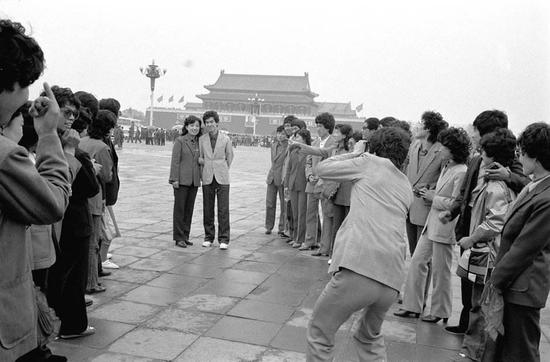 1987年5月1日,辽宁省丹东汽车制造厂23对新婚夫妇在北京天安门广场冒着蒙蒙细雨拍照纪念。他们是在厂里参与集体婚礼后来北京旅游的,旅游结婚开端在当时的年轻人中盛行。 本文图片均为新华社 材料图