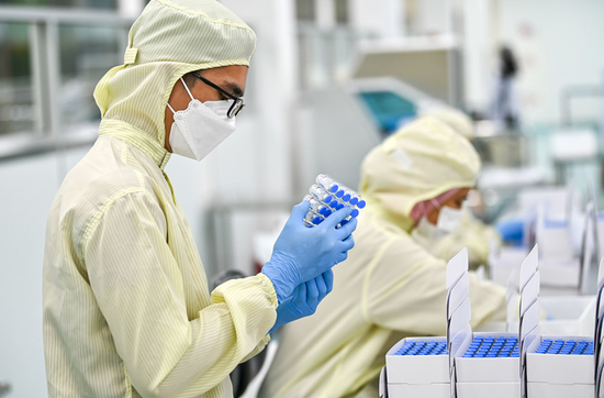 2021年10月5日，马来西亚吉隆坡，一名工人在包装本地灌装生产的科兴疫苗。新华社记者朱炜 摄