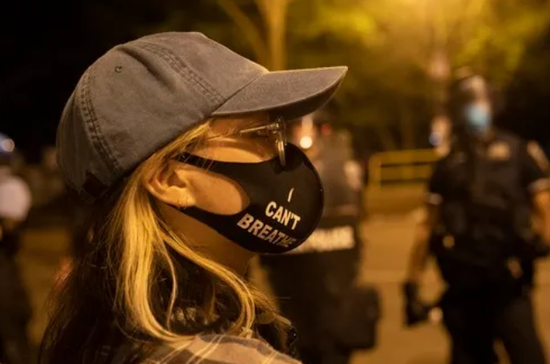 6月22日，一名女子戴着写有“我不能呼吸”的口罩在美国华盛顿白宫附近参加示威活动。新华社记者 刘杰 摄