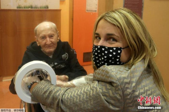 当地时间12月18日，意大利博洛尼亚一家养老院为防范新冠病毒设置“拥抱屋”，居住在这里的老人可以隔着玻璃与到访的家人团聚拥抱。图为家属与老人会面。
