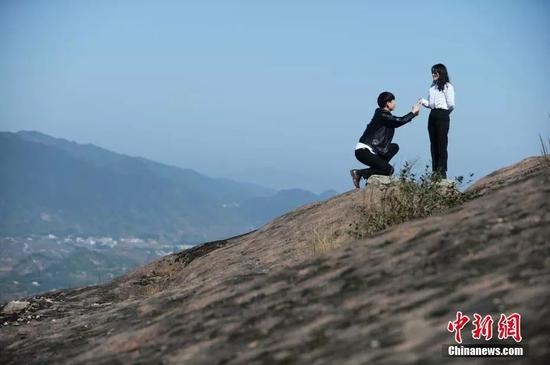 “光棍节”，一些情侣在湖南平江石牛寨的悬崖峭壁上求爱。中新社记者 杨华峰 摄