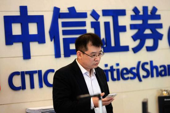 资料图:中信证券工作人员关注股市行情.