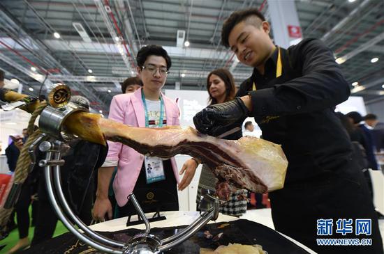 11月6日，在上海举行的第二届中国国际进口博览会上，参观者等待品尝西班牙火腿。 新华社记者 尹炣 摄