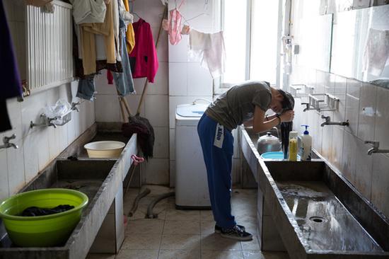 2017年4月23日，北京海淀区，北四环附近一个群租房，一名女租客在公共卫生间洗头。