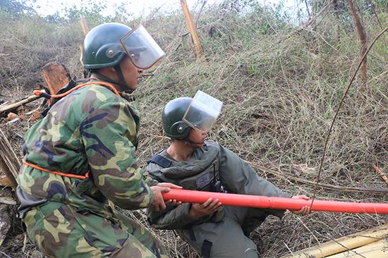 杜富国正与战友一起设置扫雷爆破筒，左侧为杜富国。杨萌 摄