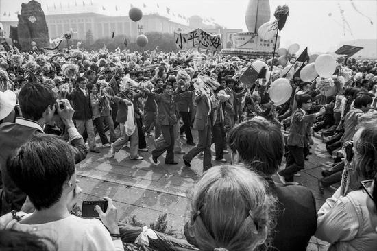 [小平您好]1984年10月1日，参加庆祝中华人民共和国成立35周年群众游行的北京大学学生，突然举起“小平您好”的横幅，通过天安门广场。第二天，此画面出现在《中国青年报》上，之后传遍世界，成为共和国历史上一段珍贵的记忆。摄影|贺延光