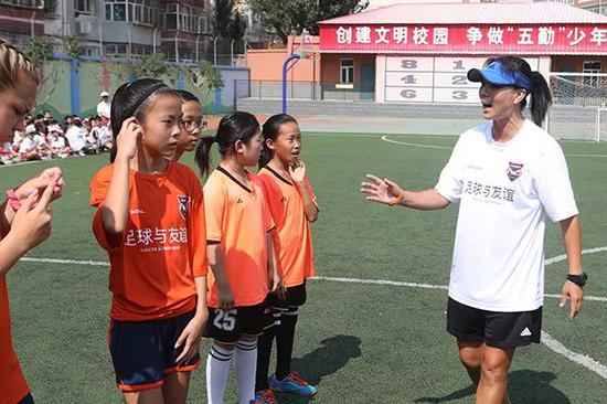 中国女足前国脚张欧影给中美青少年进走足球培训。