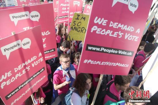 2018年10月20日，67万英国民众汇集在伦敦议会广场举行示威游行活动，呼吁对英国脱欧最终协议举行全民投票。图为示威游行人群高举标语牌，呼吁举行“人民投票”。中新社记者 张平 摄