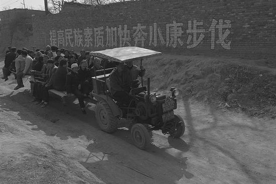 1998年，黄土高坡上的百姓生活。陕西合阳县一个村里的人坐着拖拉机去赶集。摄影|胡武功