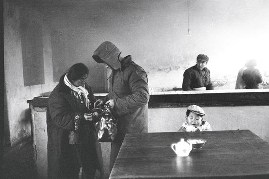 1979年，西安大众日夜小吃部，从延安来的一家三口来吃饭。摄影|胡武功