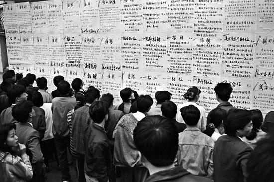 1989年，海口市东湖“人才墙”聚集的闯海人。摄影|黄一鸣
