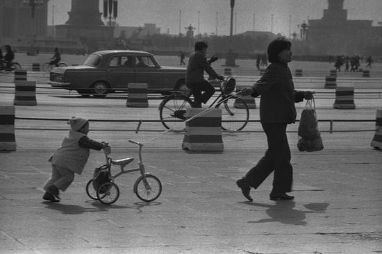 1985年，北京天安门广场，小轿车、自行车、儿童车各行其道。摄影|郭建设