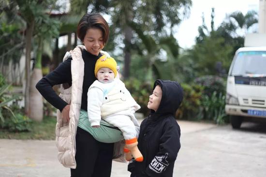▲2018年12月31日，海南省海口市，一位妈妈带着自己的两个孩子在小区里散步。（视觉中国）