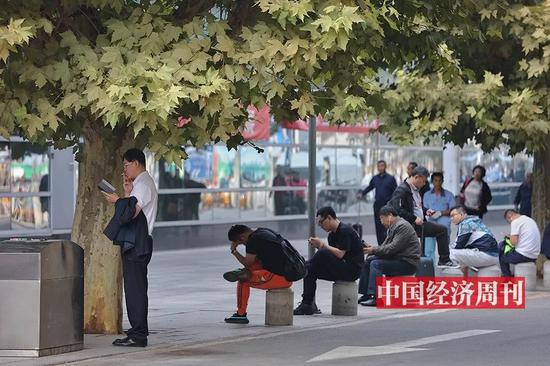 在航站楼外坐着休息的旅客（《中国经济周刊》首席摄影记者 肖翊 | 摄）