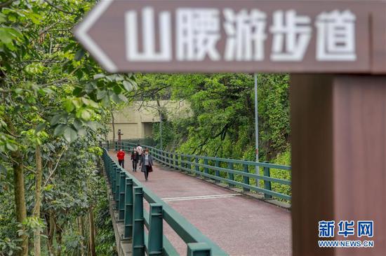 游客沿着重庆半山崖线步道的虎头岩段前行（4月3日摄）。 新华社记者 刘潺 摄