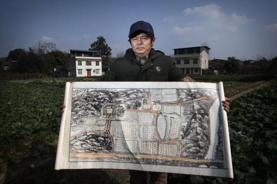 ▲2019年1月19日，四川江油，在杨海军所租住的村子里，他拿着根据自己走失前对家及家周边的记忆所画的画。新京报记者 尹亚飞 摄