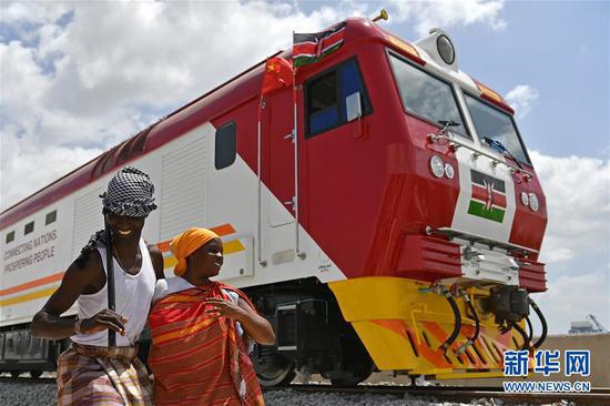 2017年1月11日，在肯尼亚蒙巴萨，当地民众在中国承制的蒙内铁路首批内燃机车旁载歌载舞。蒙内铁路是肯尼亚自独立以来最大的基础设施工程，项目累计为当地直接创造逾4.6万个工作岗位。 新华社记者孙瑞博摄