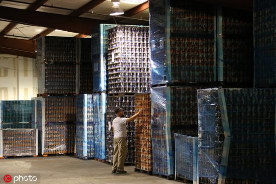 资料图：美国佛罗里达州某啤酒厂，工作人员正在检查装有空铝罐的架子 图自IC photo