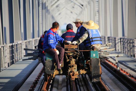 ▲中铁大桥局中俄同江铁路大桥项目的建设者作业归来。（6月4日摄）本报记者谢锐佳摄