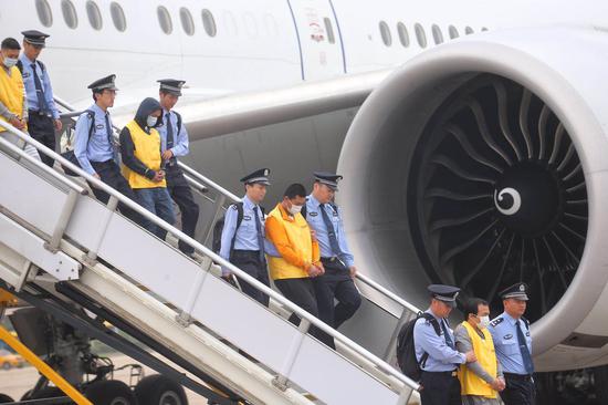 6月7日7时许，一架中国民航包机降落在首都国际机场，94名台湾籍电信网络诈骗嫌疑人被民警从西班牙押解回国。新京报记者 王贵彬 摄