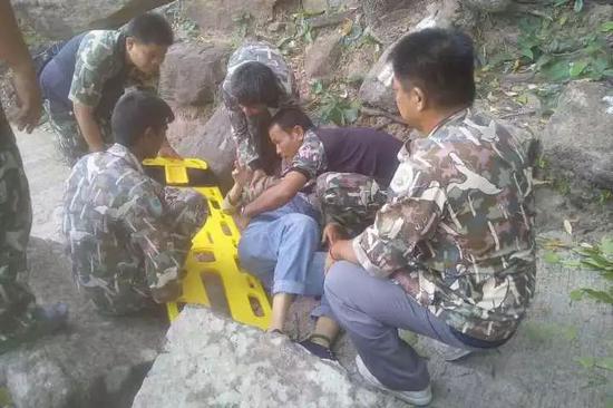 6月9日，中国女子在泰国坠崖，公园管理人员正在帮助她（图源：泰国《曼谷邮报》）