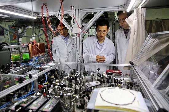 资料图片：中国科大教授和学生们在检查光量子计算机的运行情况。（新华社）